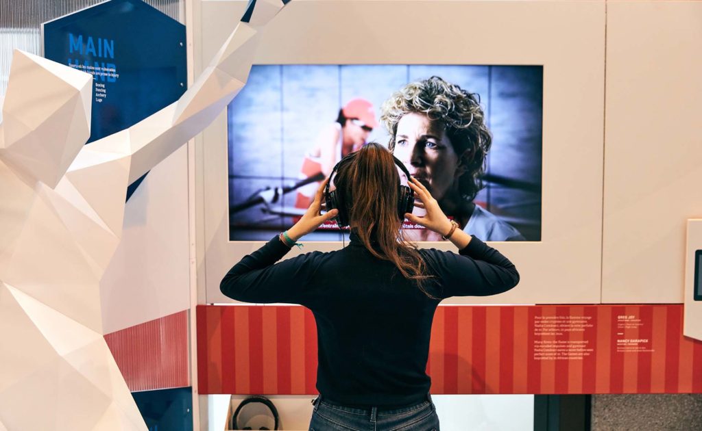 A woman watching a video screen at the Canadian Olympic House experience