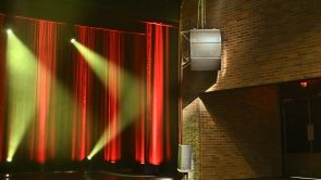 XYZ-Technologies-Theatre-du-Cuivre-Close-up-of-stage-right-with-professional-D&B-audio-system-and-dynamic-red-yellow-lighting