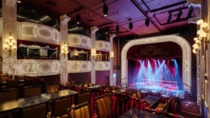 XYZ-Technologies_CafConc_Wide-view-of-the-cabaret-style-theatre-with-stage-lit-in-red-and-blue