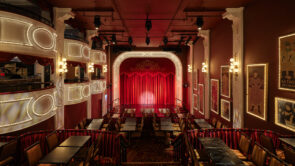 XYZ-Technologies_CafConc_wide-view-of-the-cabaret-style-theatre-stage-with-closed-red-curtains
