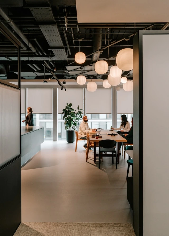 Espace de coworking vu de loin avec gens discutant à une table