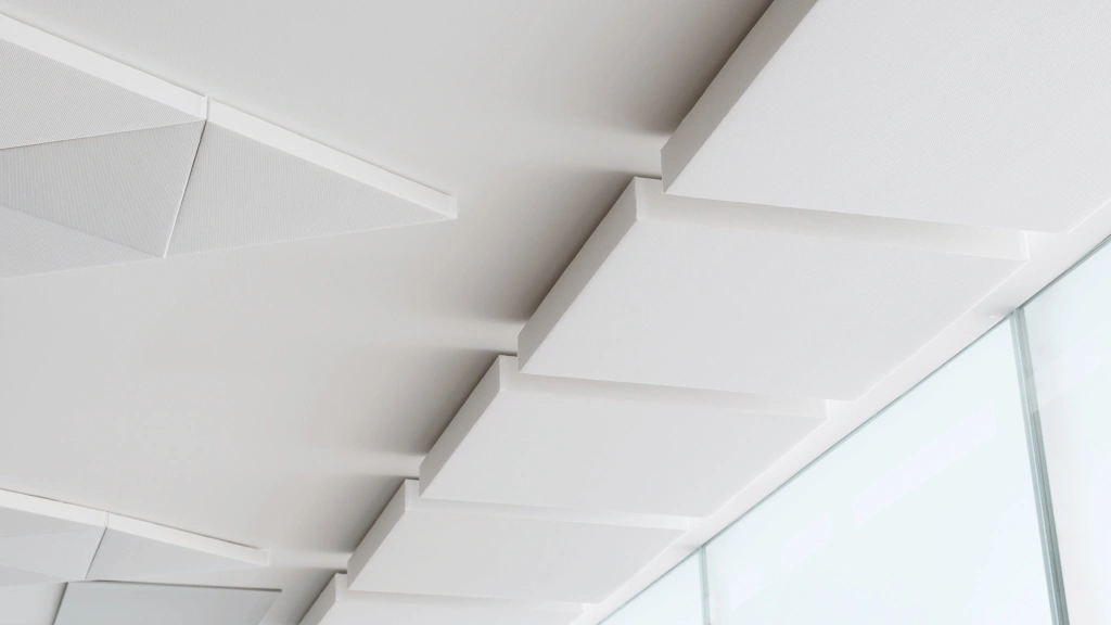 Panneau acoustiques carrés et triangulaires blancs accrochés aux plafonds